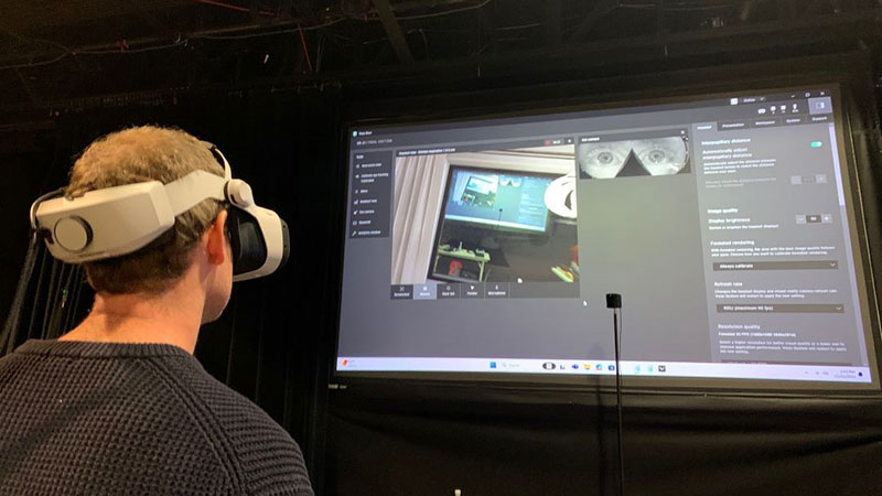 Person with VR headset on in front of a presentation screen