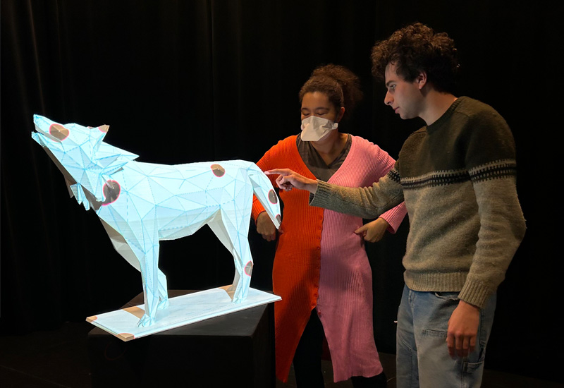 two onlookers reflecting on a 3D printed lobo statue at ARTSLab